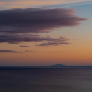 Wolken über der Insel Montechristo im tyrrhenischen Meer vor der Küste der Toskana in der Abenddämmerung, Maremma, Italien