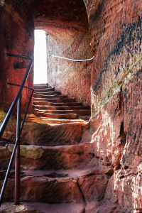 Treppenaufgang durch den Felsen in der mittelalterlichen Burgruine Klein-Wasigenstein im Gegenlicht der Sonne, Wasgau, Elsass, Frankreich