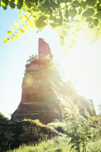 Halsgraben und Bergfried der mittelalterlichen Burgruine Groß-Wasigenstein auf einem Felsen im Gegenlicht der Sonne, Wasgau, Elsass, Frankreich