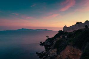 Leuchtturm von Talamone vor dem Meer und dem Monte Argentario im Zwielicht der Abenddämmerung, Toskana, Italien