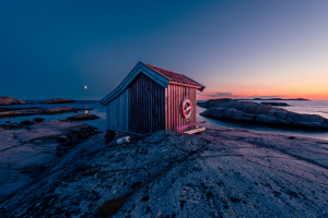 Holzhütte im leuchtenden Sonnenuntergang auf den Felsen im Naturreservat Tjurpannan in den Schären der schwedischen Westküste