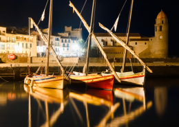 Bunte Segelboote an der beleuchteten Promenade im Hafen der Altstadt von Collioure bei Nacht, Cote Vermeille, Languedoc-Roussillon, Frankreich
